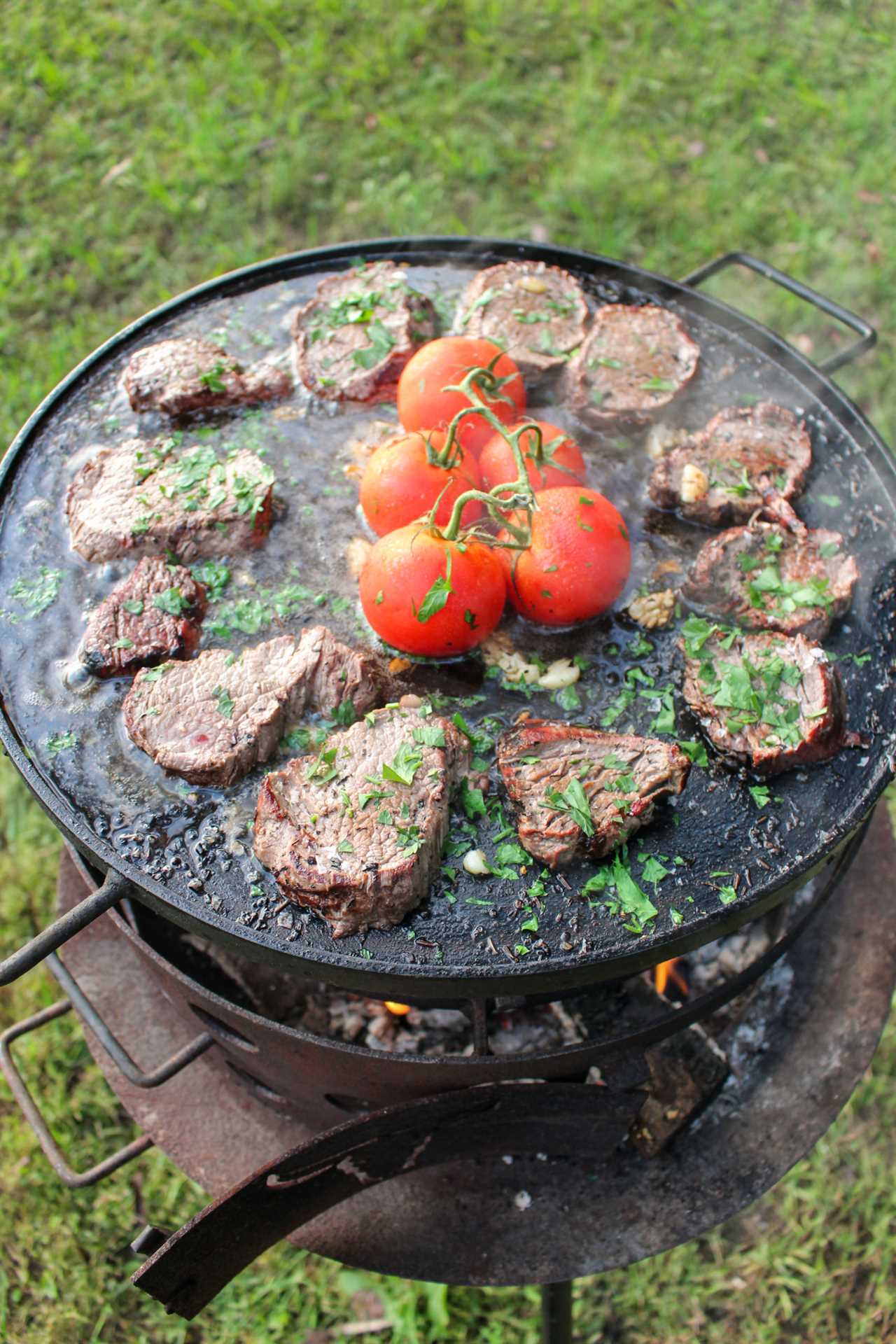 Salt Bae Steak sizzling on over the fire.