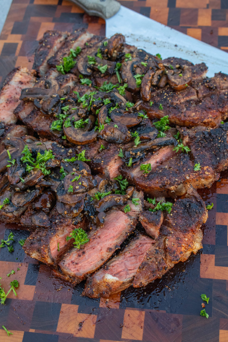 New York Strips with Bourbon Mushrooms sliced and ready to serve.