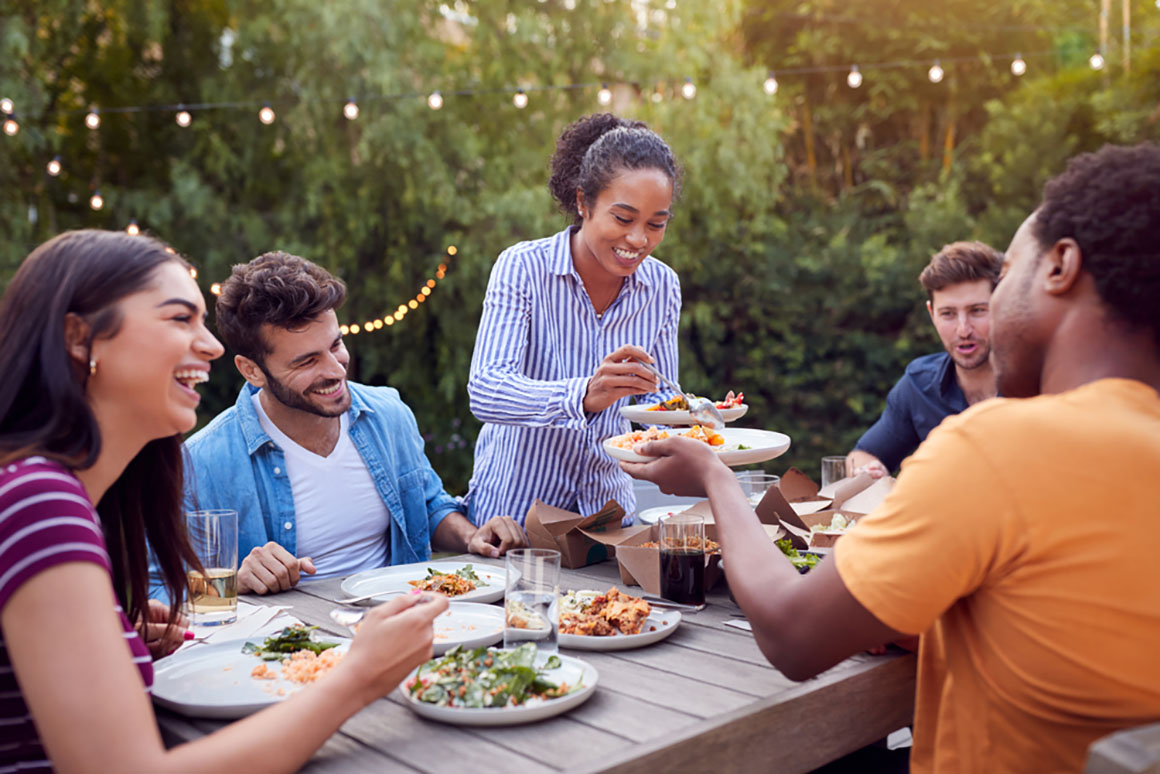 a group of friends eating bbq together