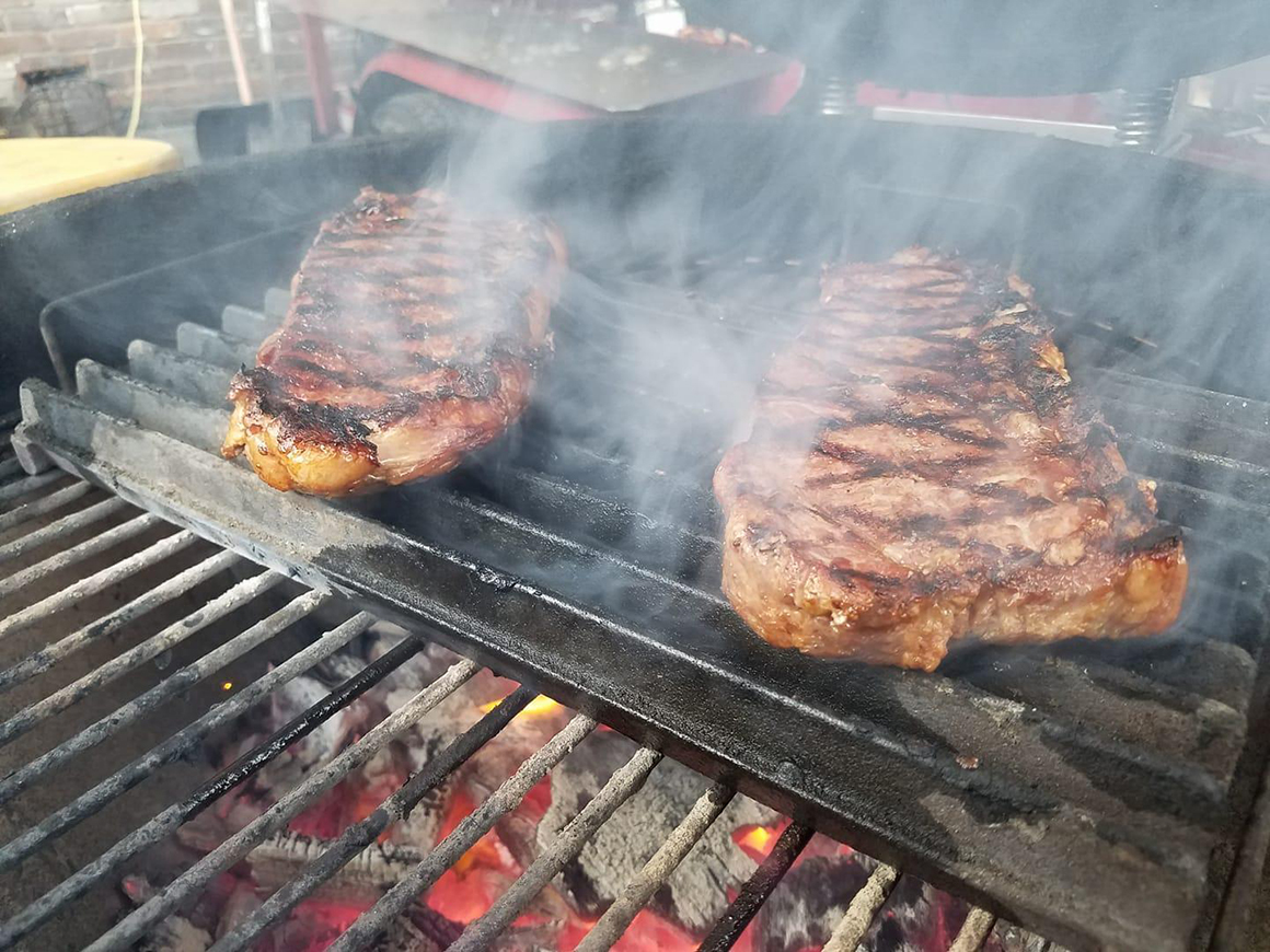 two steaks on a grill