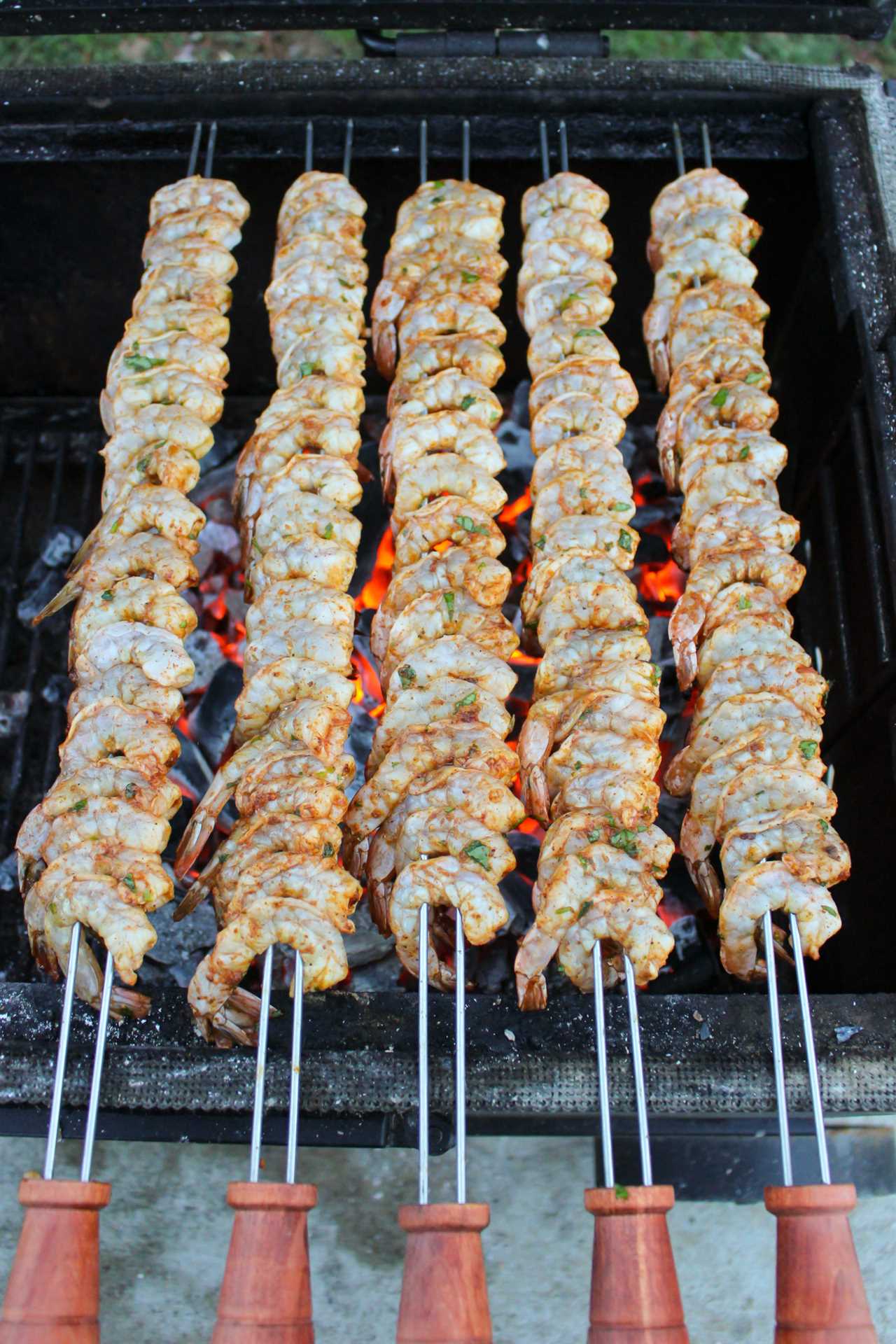 Spicy Tequila Lime Shrimp Skewers getting placed on the grill.