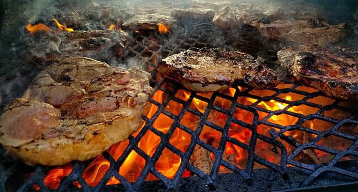 chicken breasts cooking on a grill