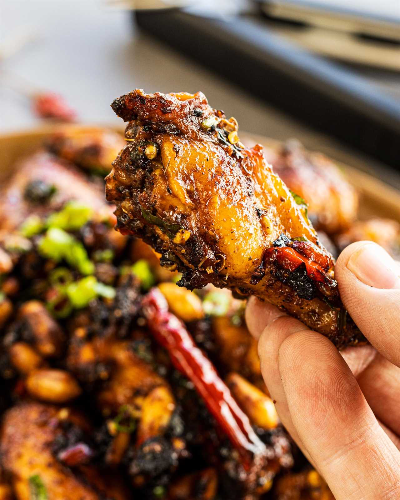 Grilled Kung Pao Chicken Wings a single wing held up close.