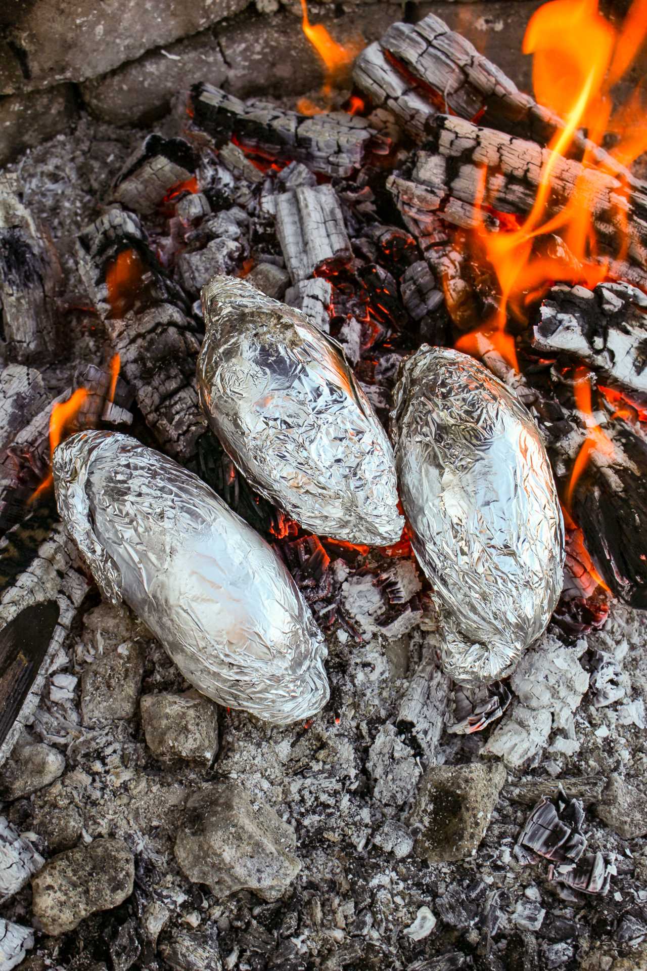 Baked potatoes sitting the coals.