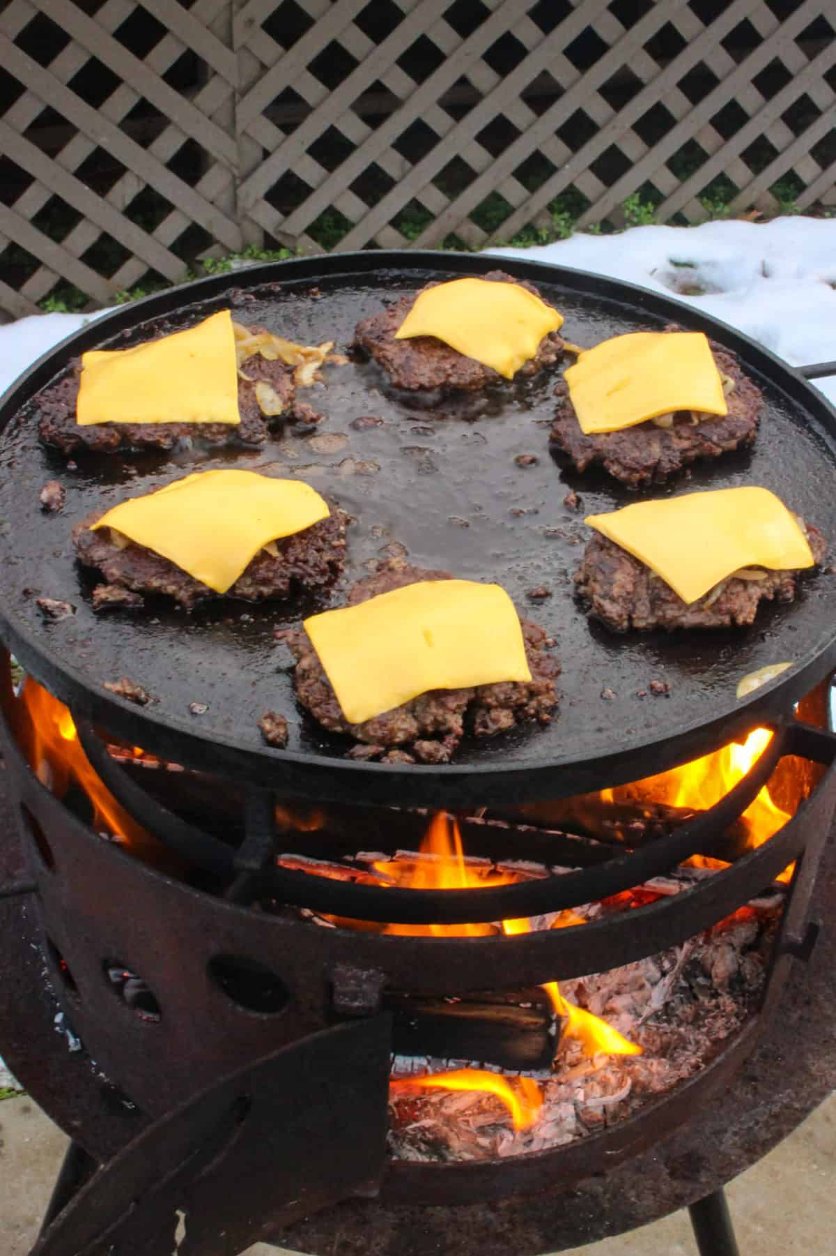 Adding cheese to the patties.