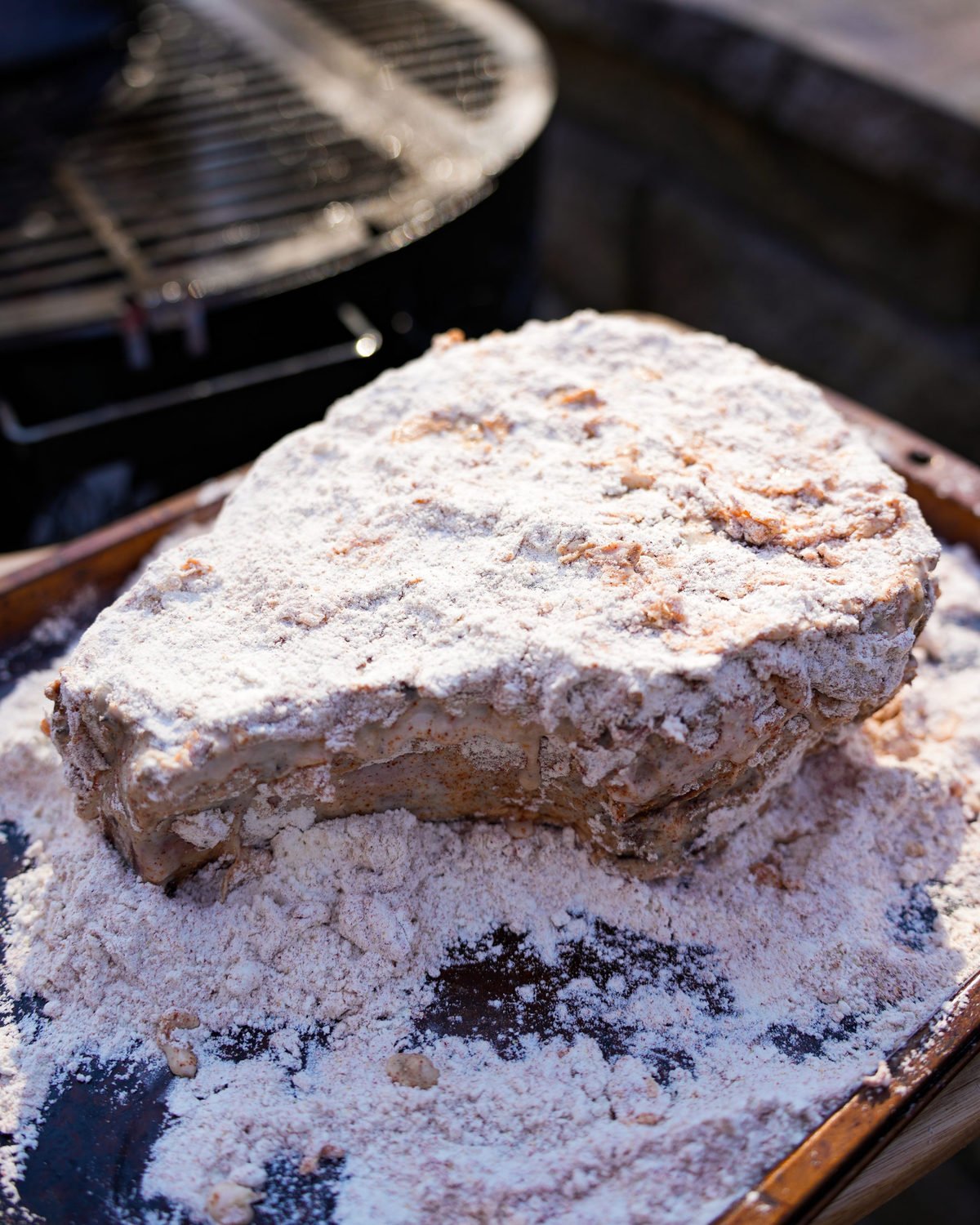 Coating the ribeye in flour and seasonings before frying.