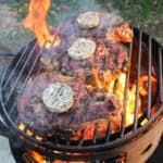 Reverse Seared Ribeyes being topped with Black Garlic Butter.