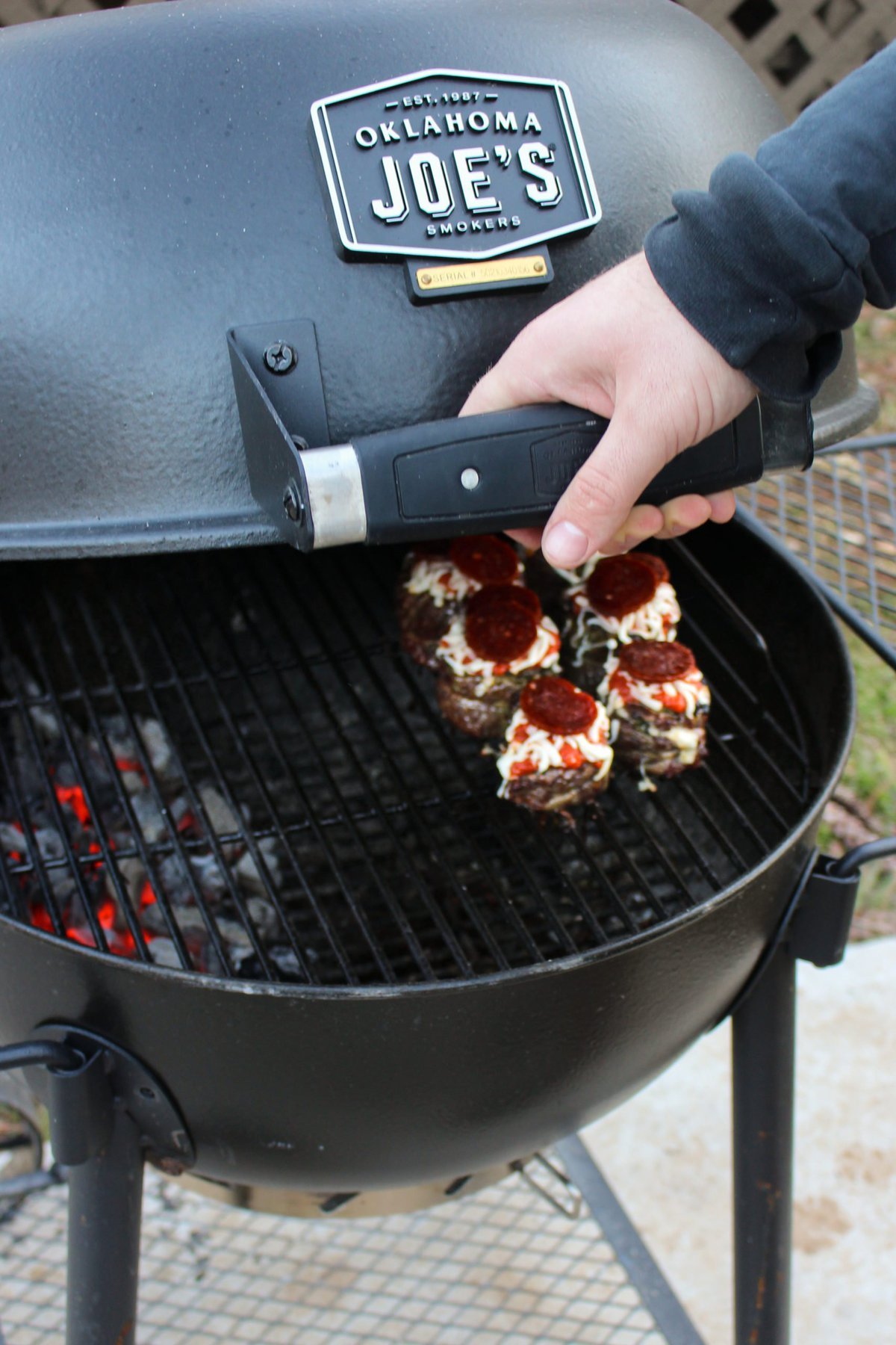 Opening the Oklahoma Joe's Blackjack grill to reveal the pizza pinwheels.