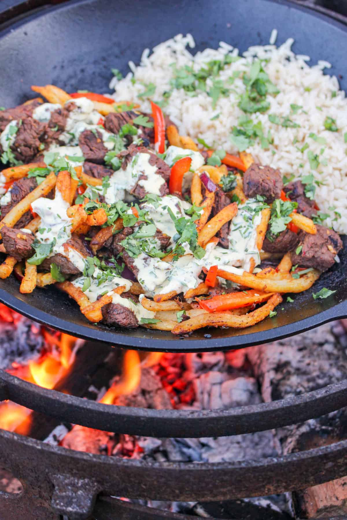 Peruvian Steak Stir Fry in the wok with rice and covered in the Aji Amarillo Mayo..