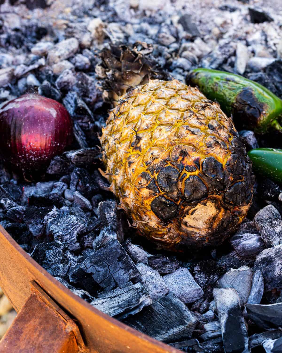 The pineapple for the salsa roasting directly on the coals. 