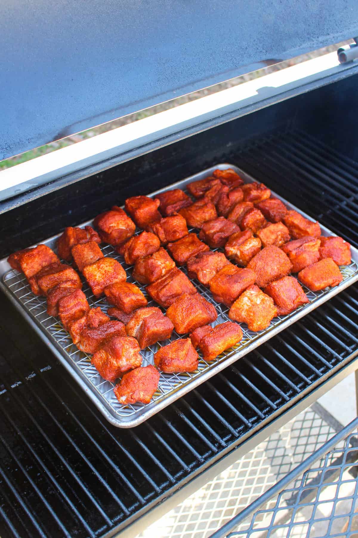 Honey Garlic Pork Belly Burnt Ends getting placed on the smoker. 