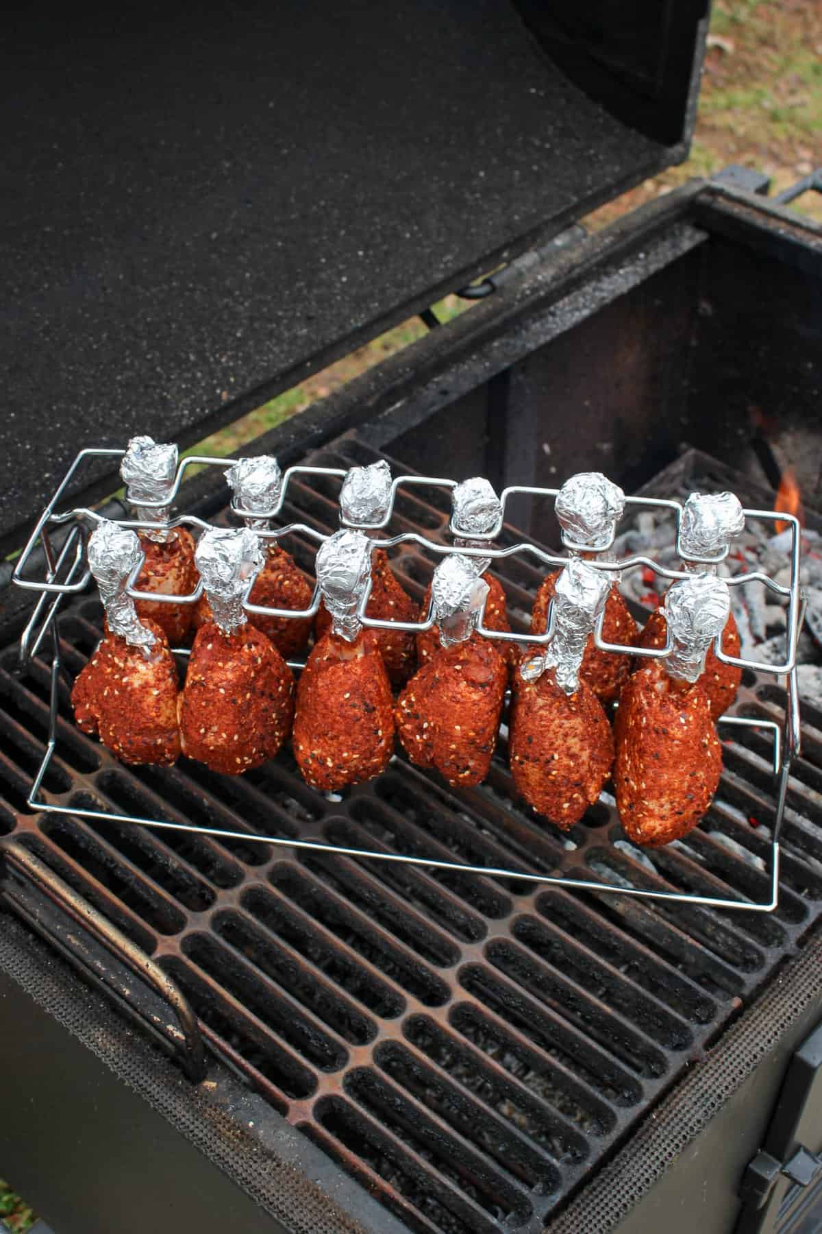 Honey Korean BBQ Chicken Lollipops hanging from a rack placed on the smoker. 