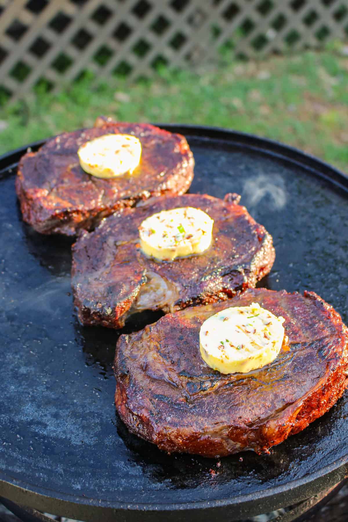 Adding the Honey Chili Butter onto the steaks.