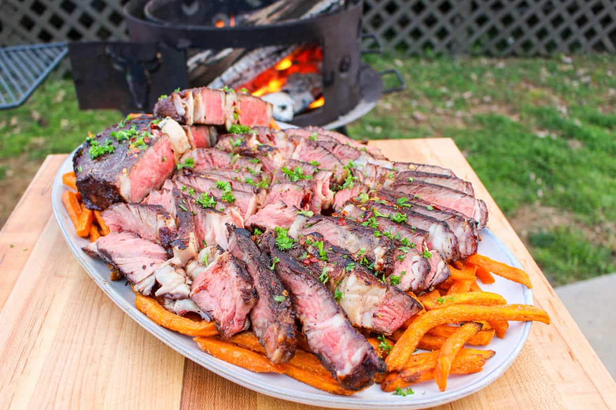 Sliced ribeyes over some sweet potato fries.