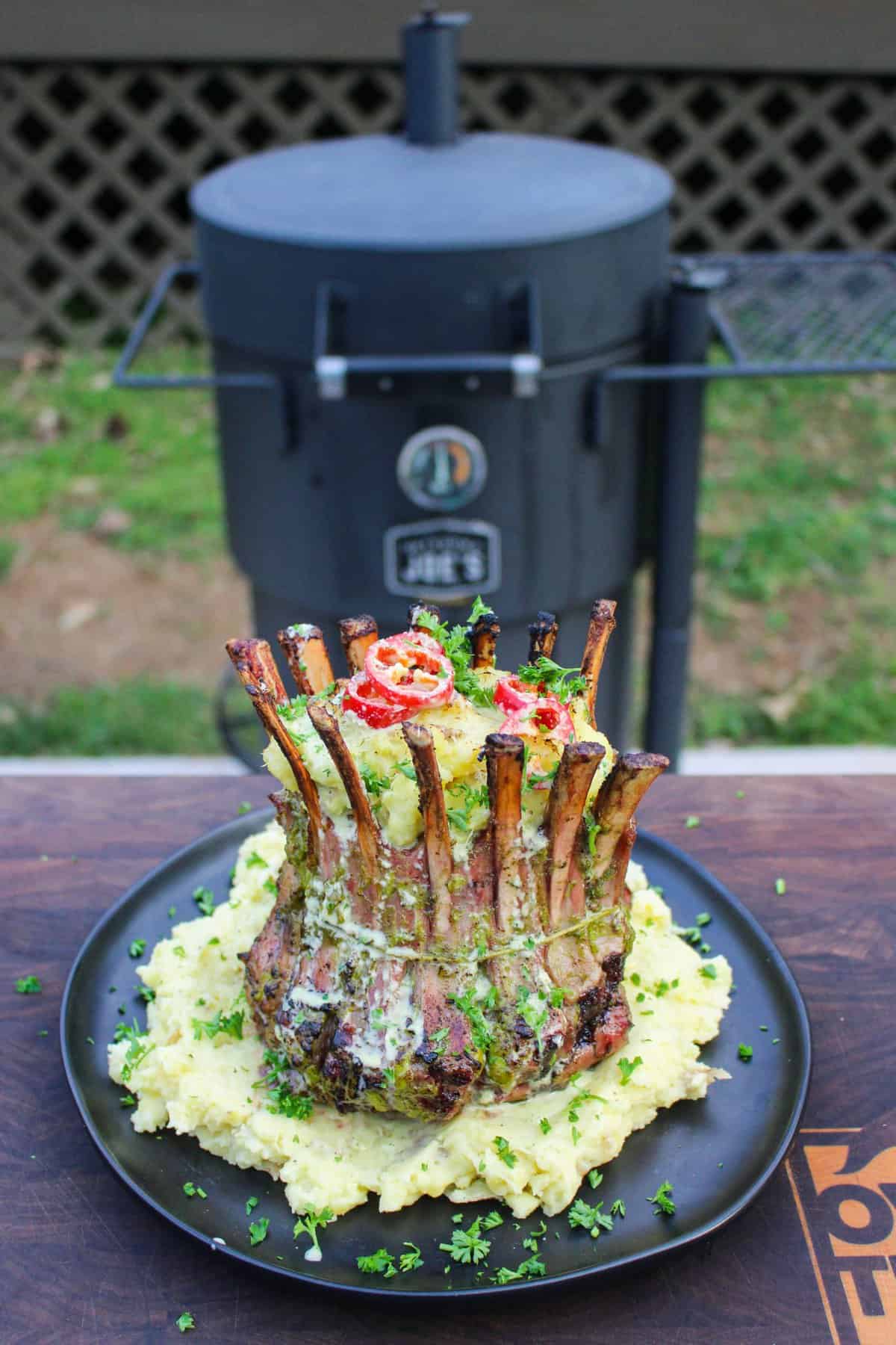 The plated lamb with the smoker in the background.