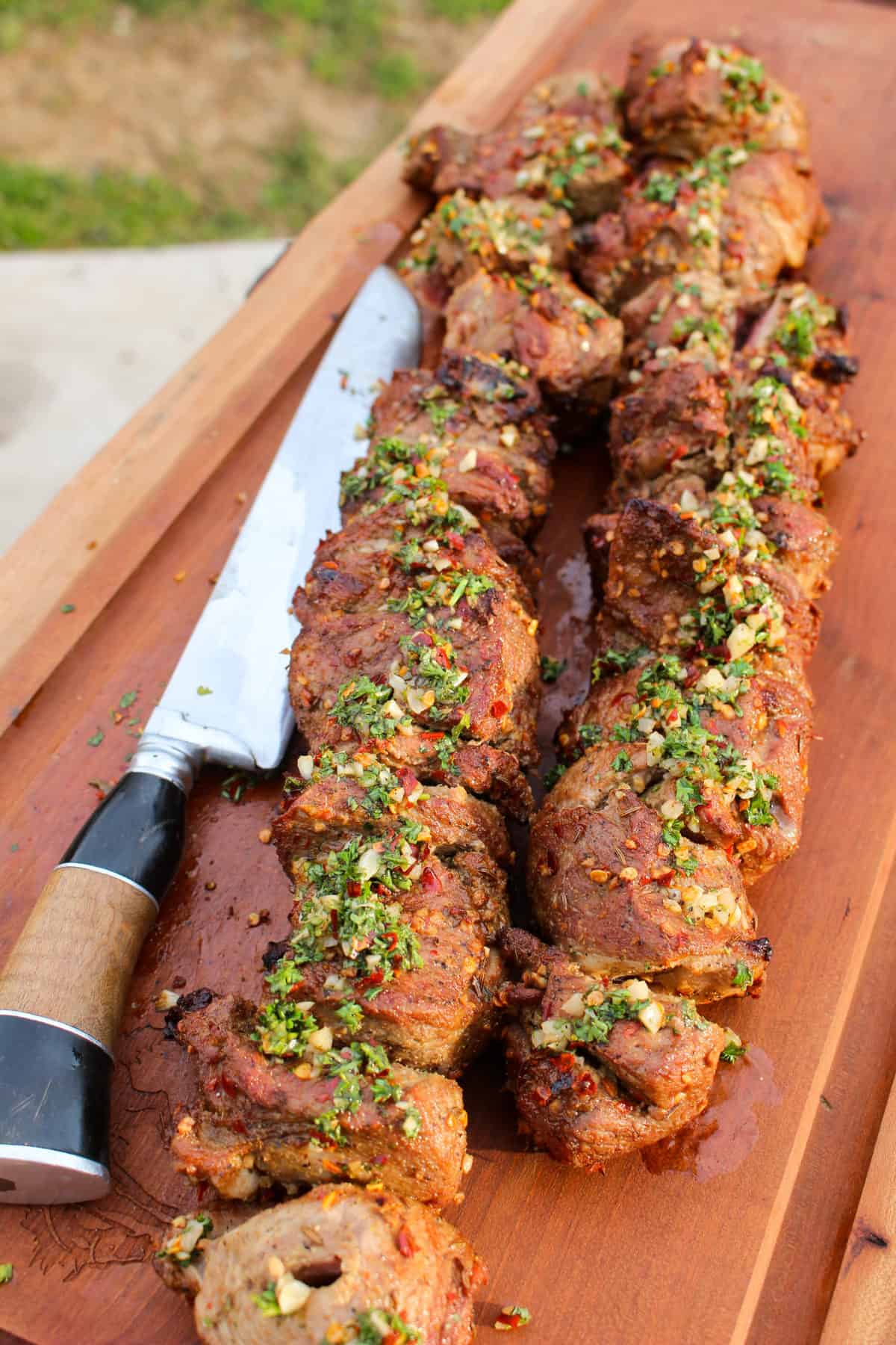 Spiced Lamb Kebabs with Mint Chimichurri sitting on a cutting board.