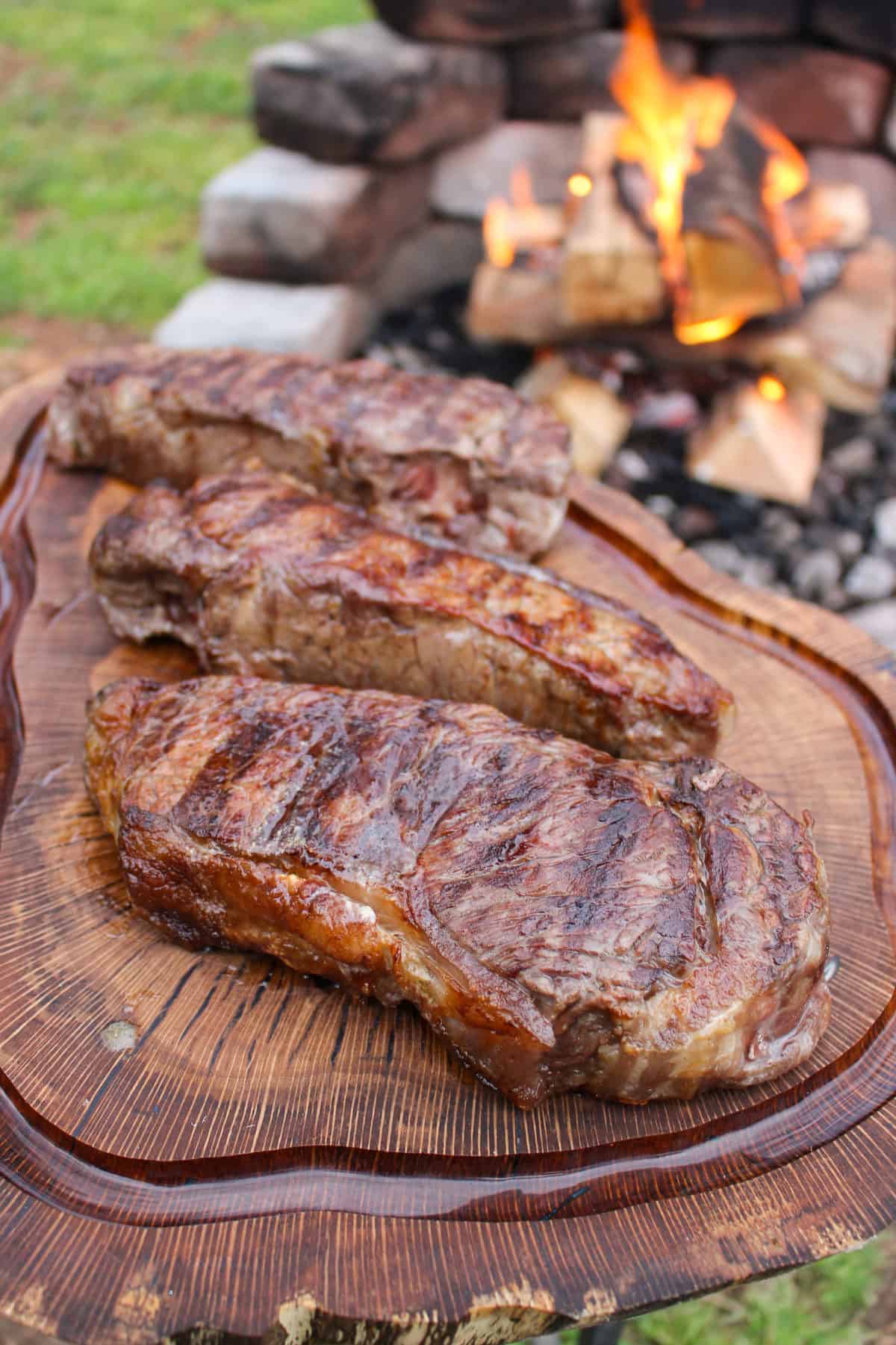 Steaks resting on the cutting board after being pulled off the grill. 