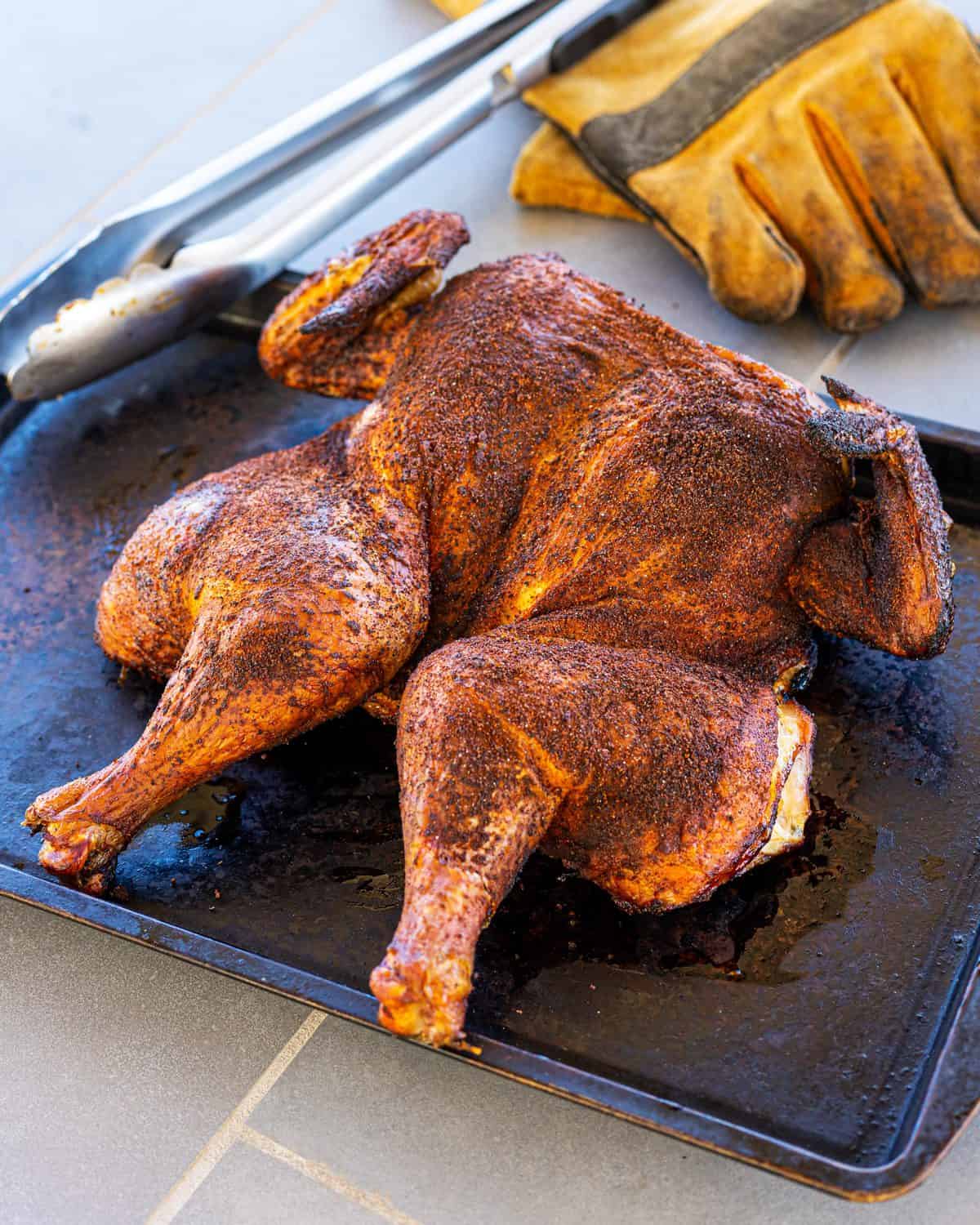 Pulling the cooked chicken from the smoker.