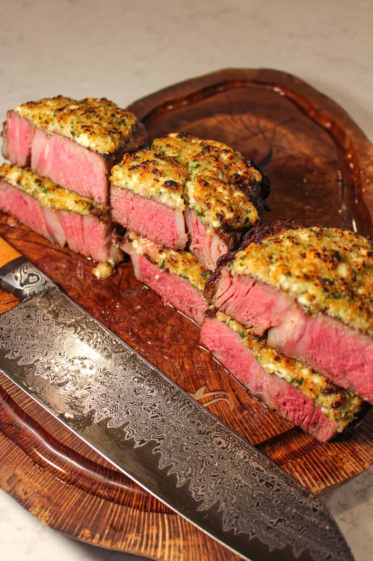 finished steaks on a cutting board with a knife