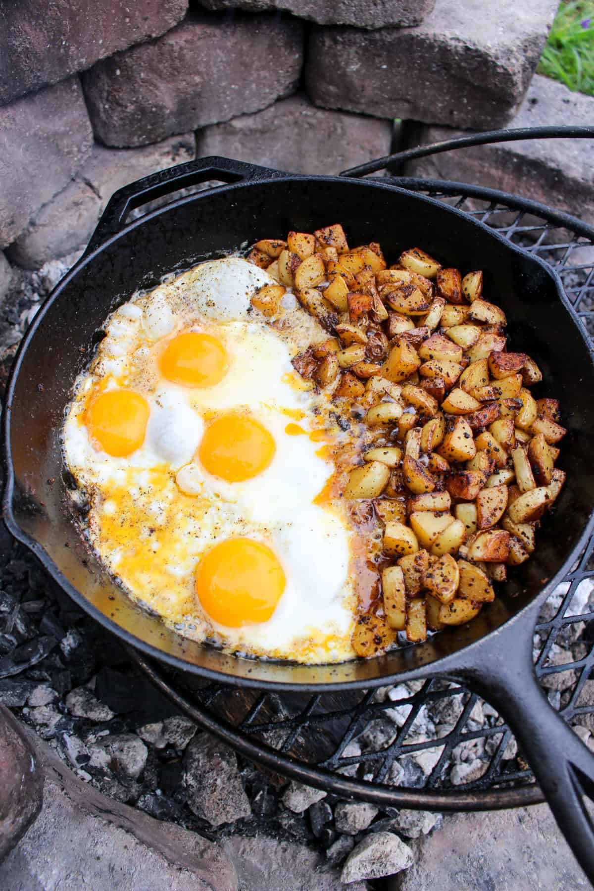 overhead of a skillet with cooked, fried eggs and potatoes