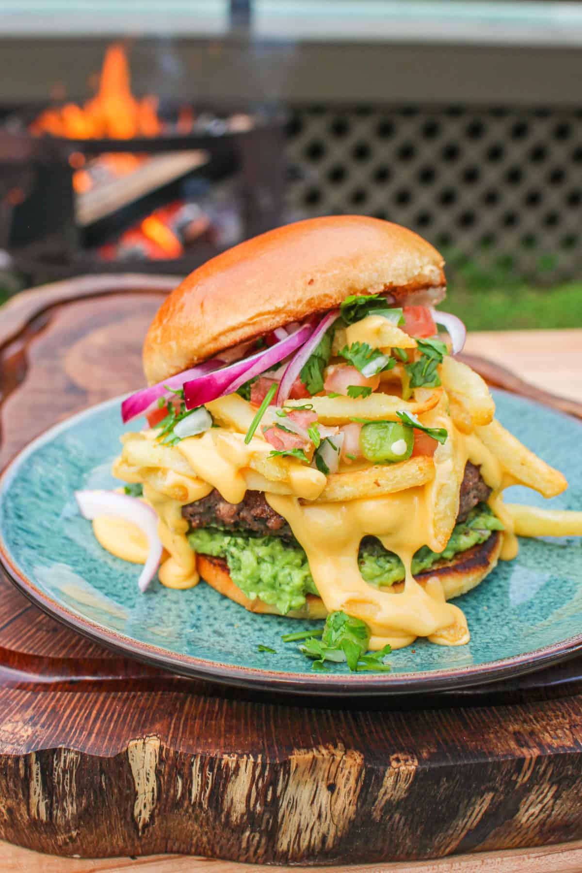 california burrito style burger on a blue plate with a grill in the background