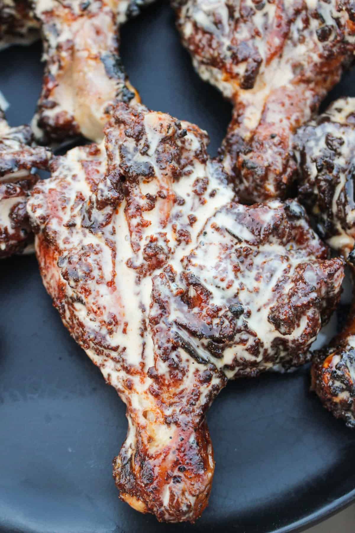 a closeup of chicken drumsticks covered in sauce on a plate