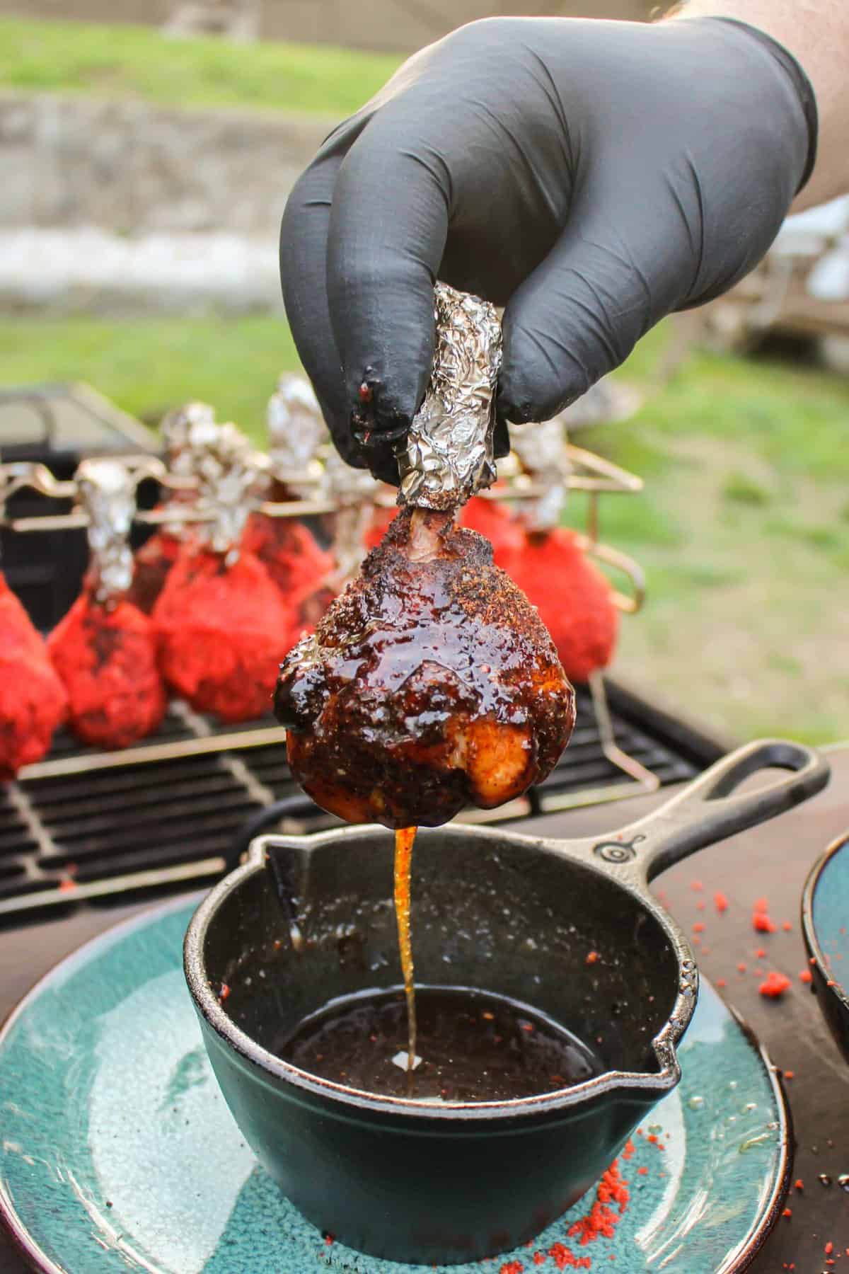 Chicken Lollipop getting dunked in the glaze.