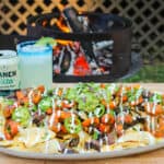 platter full of surf and turf nachos with a margarita in the background