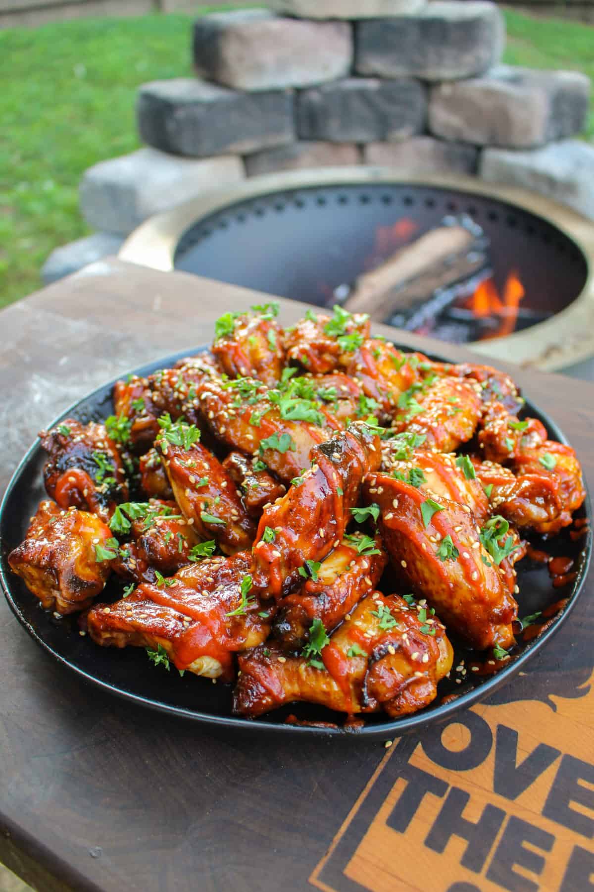 side view of a plate filled with chicken wings on a cutting board