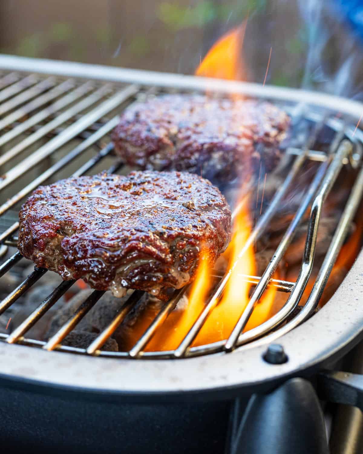 Close up of flames kissing the beef burger patties.