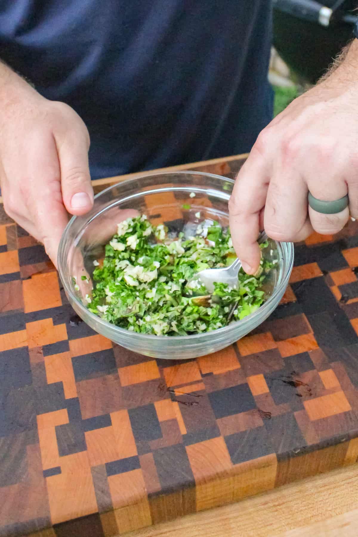 overhead of charred scallion gremolata for grilled steak pinwheels being mixed in a small bowl