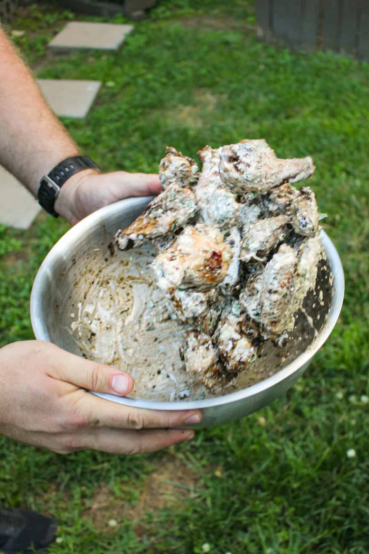 chicken wings being tossed with elote sauce