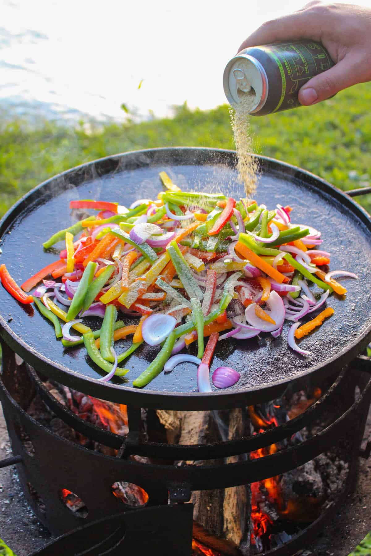 fajita veggies being sprinkled with seasoning