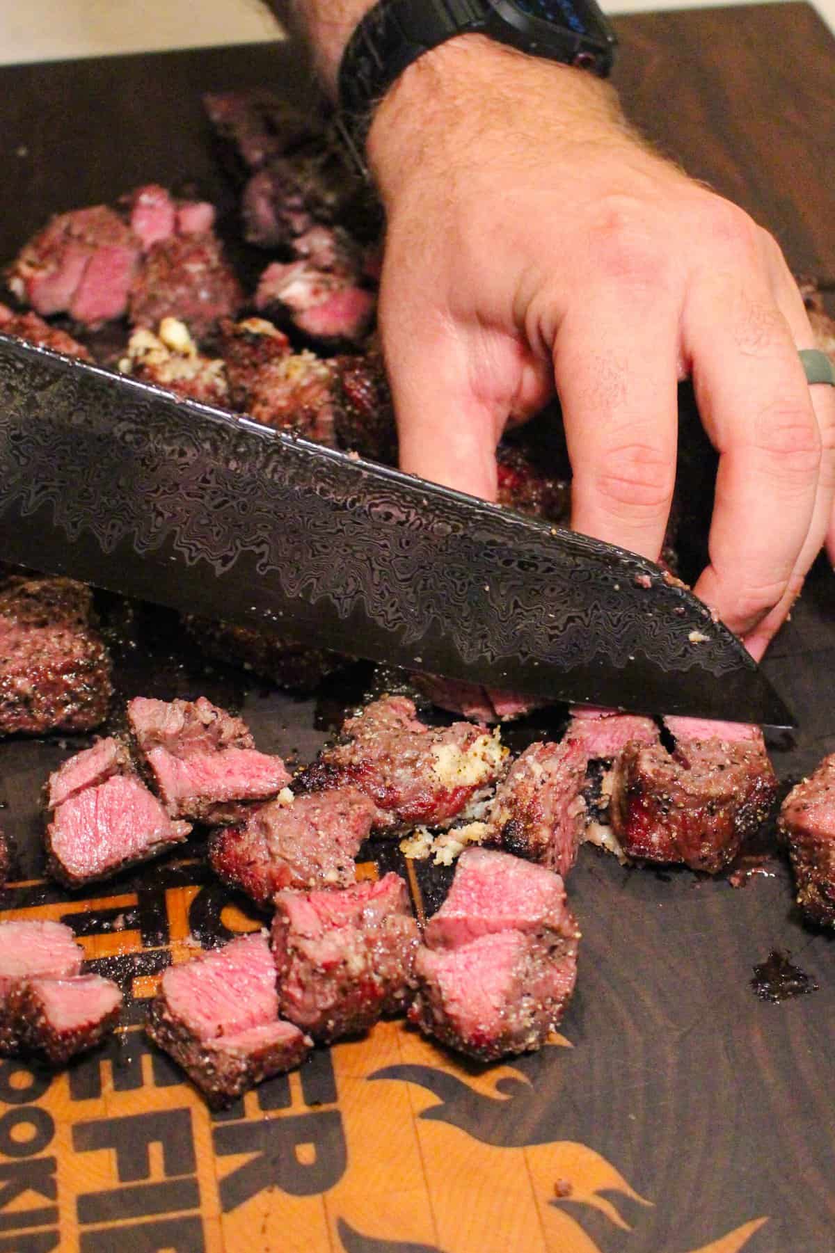 pieces of steak on a cutting board being chopped