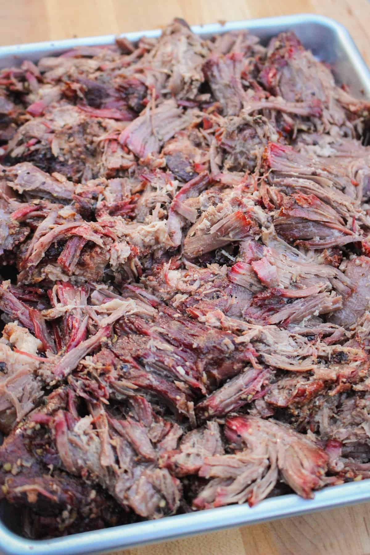 closeup of pulled beef chuck roast on a baking sheet