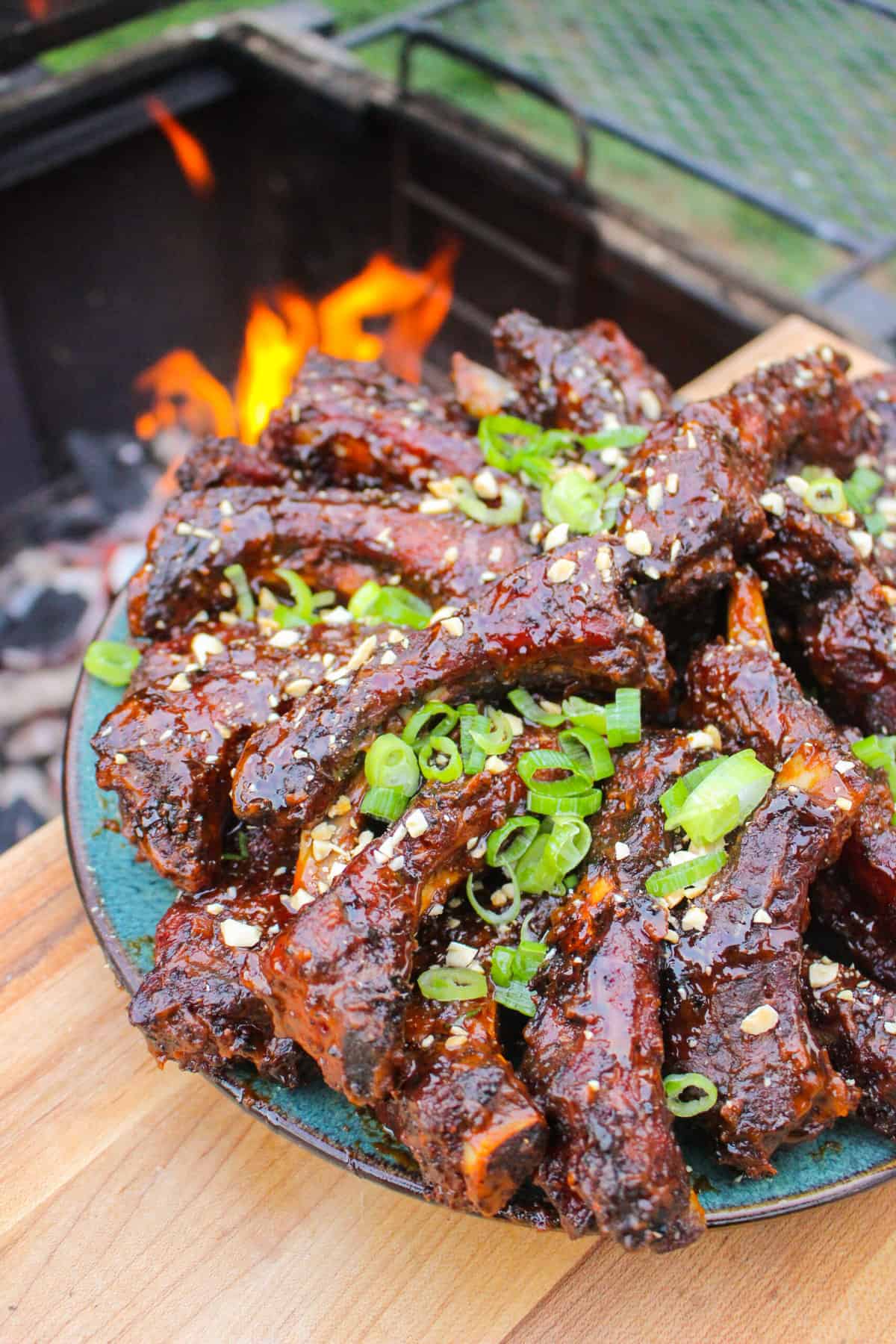 overhead of a plate full of cooked ribs next to a smoker