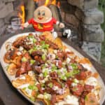 overhead of a plate of steak and blue cheese kettle chips next to a small Idaho potatoes doll