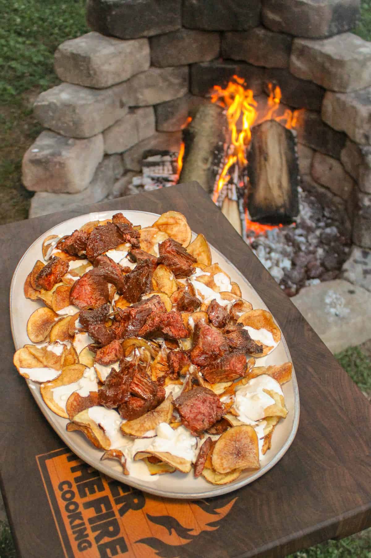 overhead of a plate of kettle chips topped with blue cheese dressing and steak