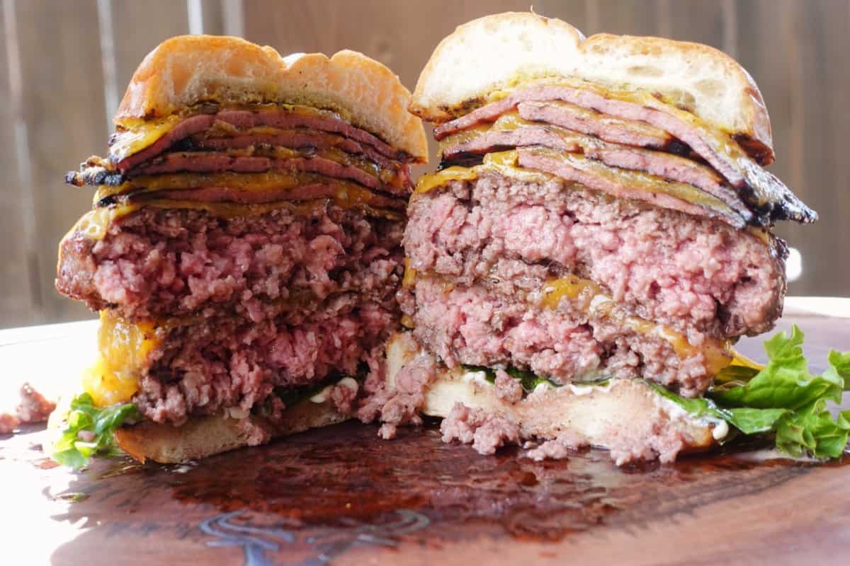 The Ultimate Smoked Bologna Cheeseburger sliced in half.