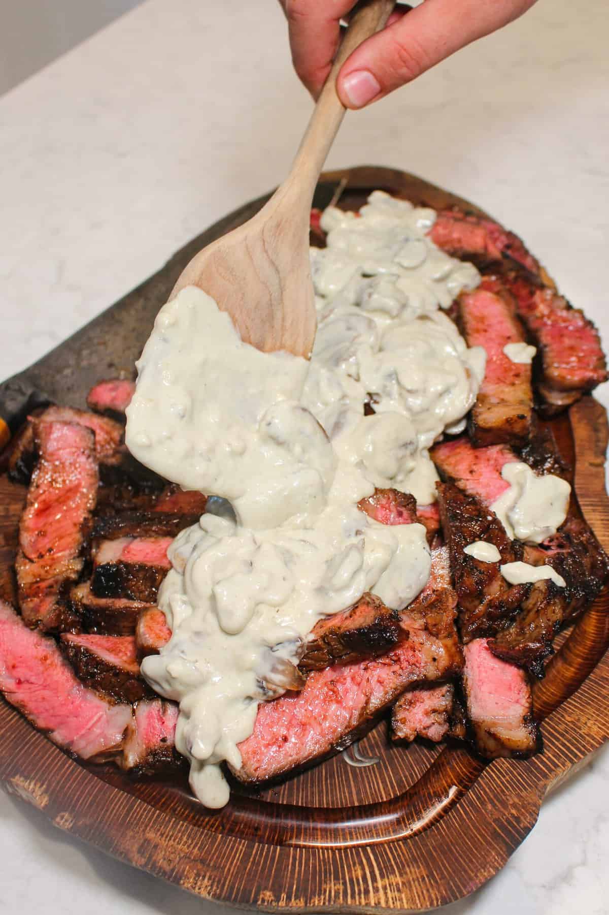 a pile of bourbon marinated ribeyes covered in cream sauce from above