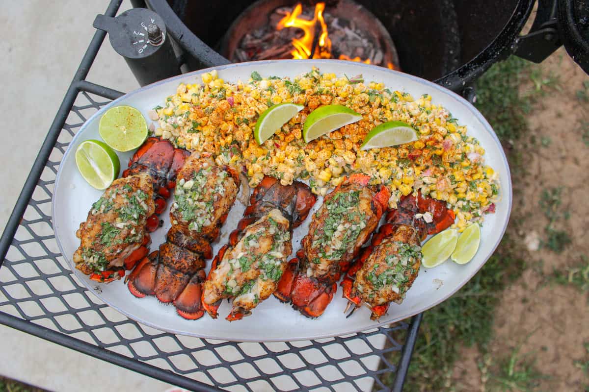 overhead of a platter filled with smoked lobster tails with esquites