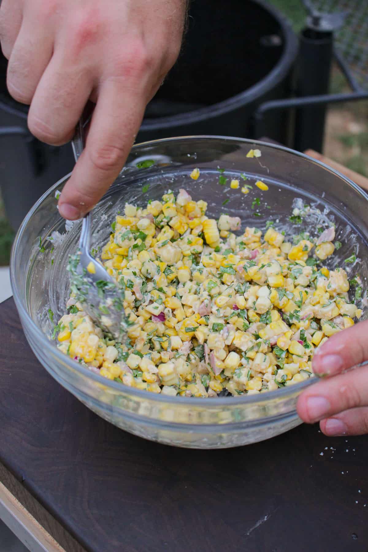 finished esquite being mixed in a bowl