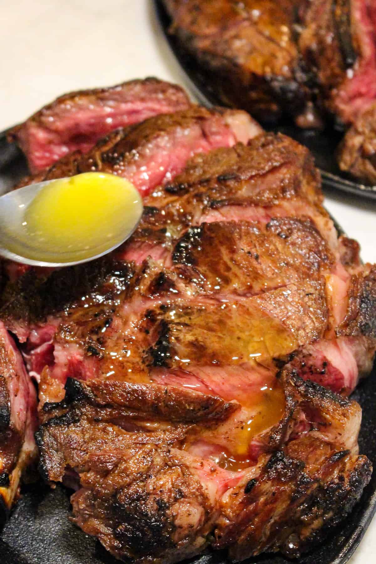 garlic butter being drizzled over steak