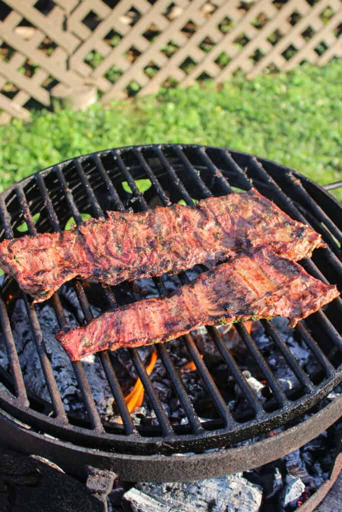 The carne asada after being flipped on the grill.