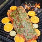 planked salmon on the grill topped with chili lime sauce overhead