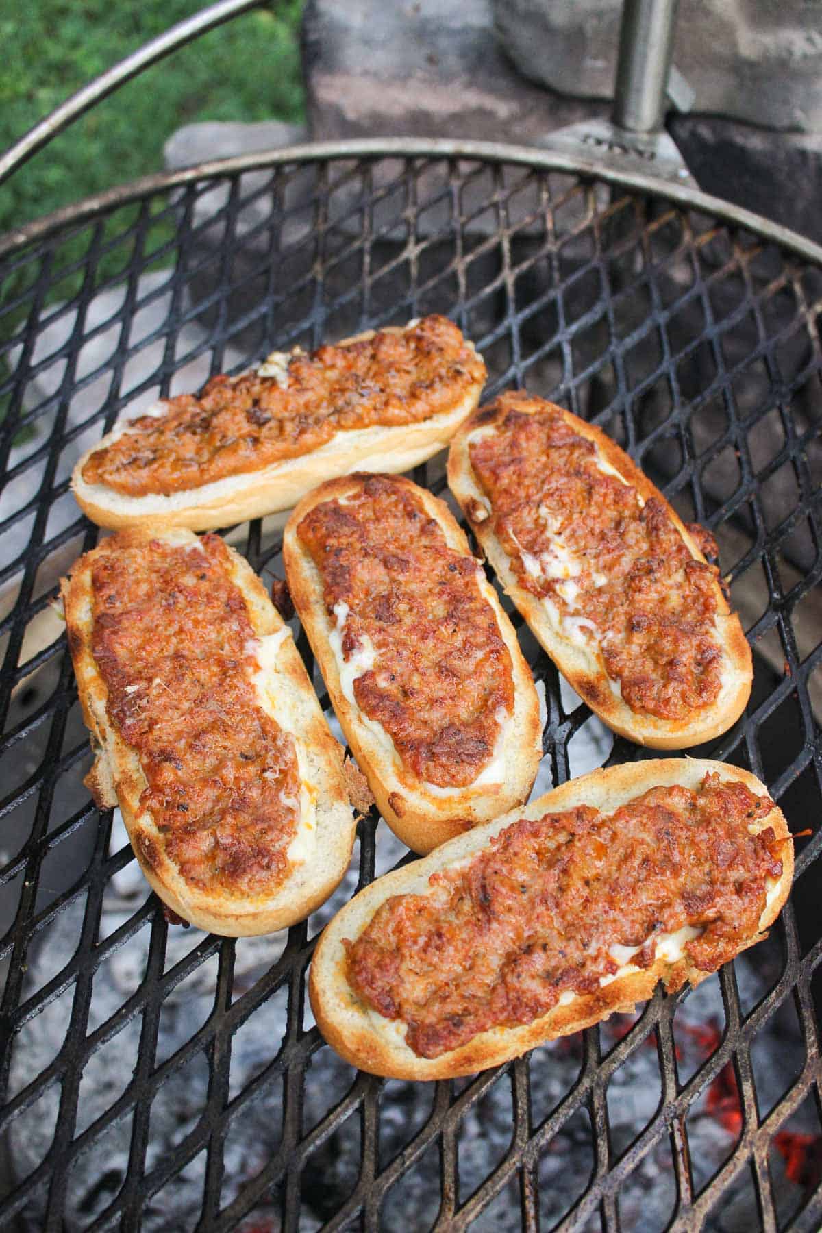 grilled chorizo covered rolls on a grill grate from above