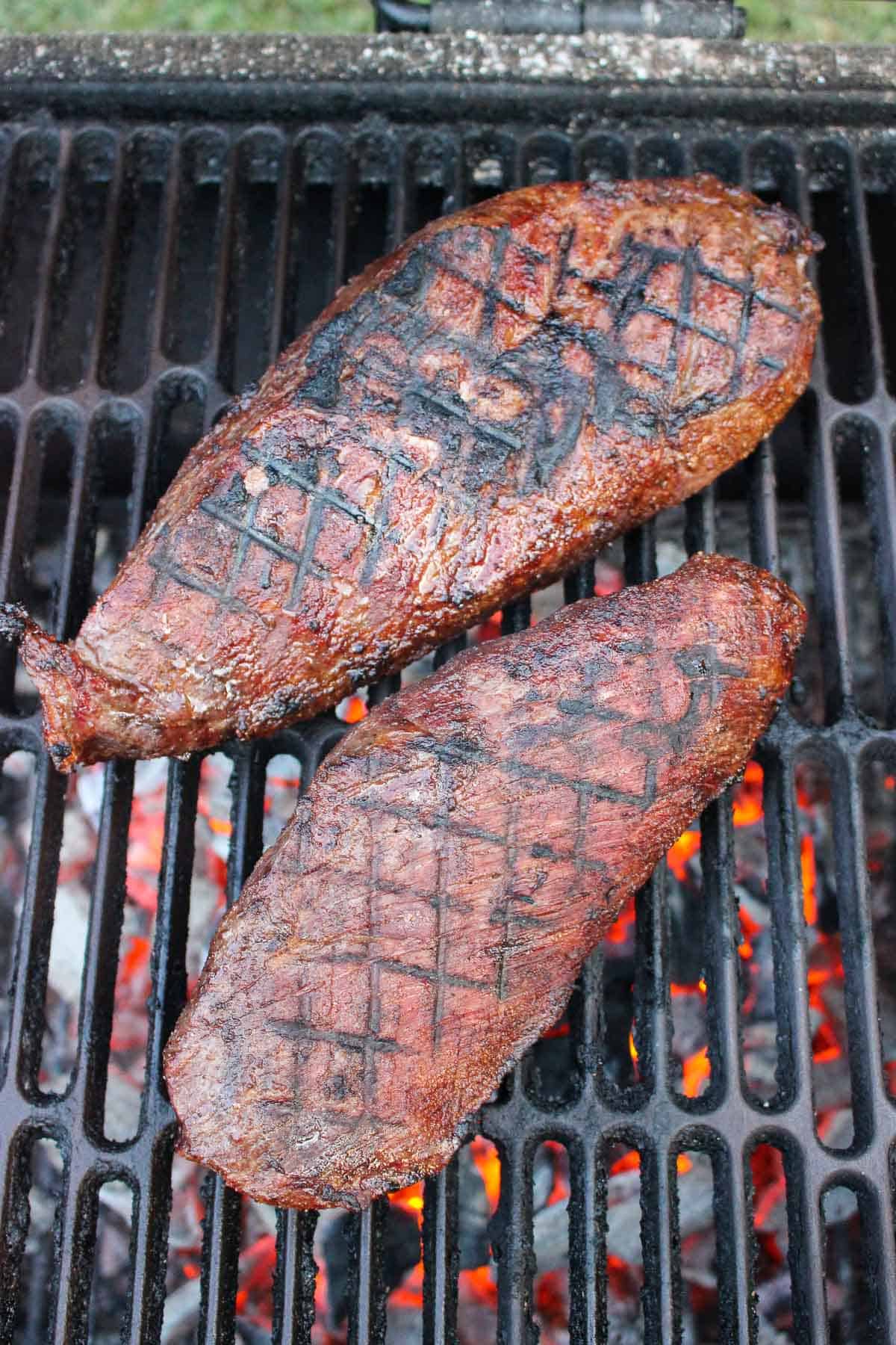 overhead of two seared steaks on a grill