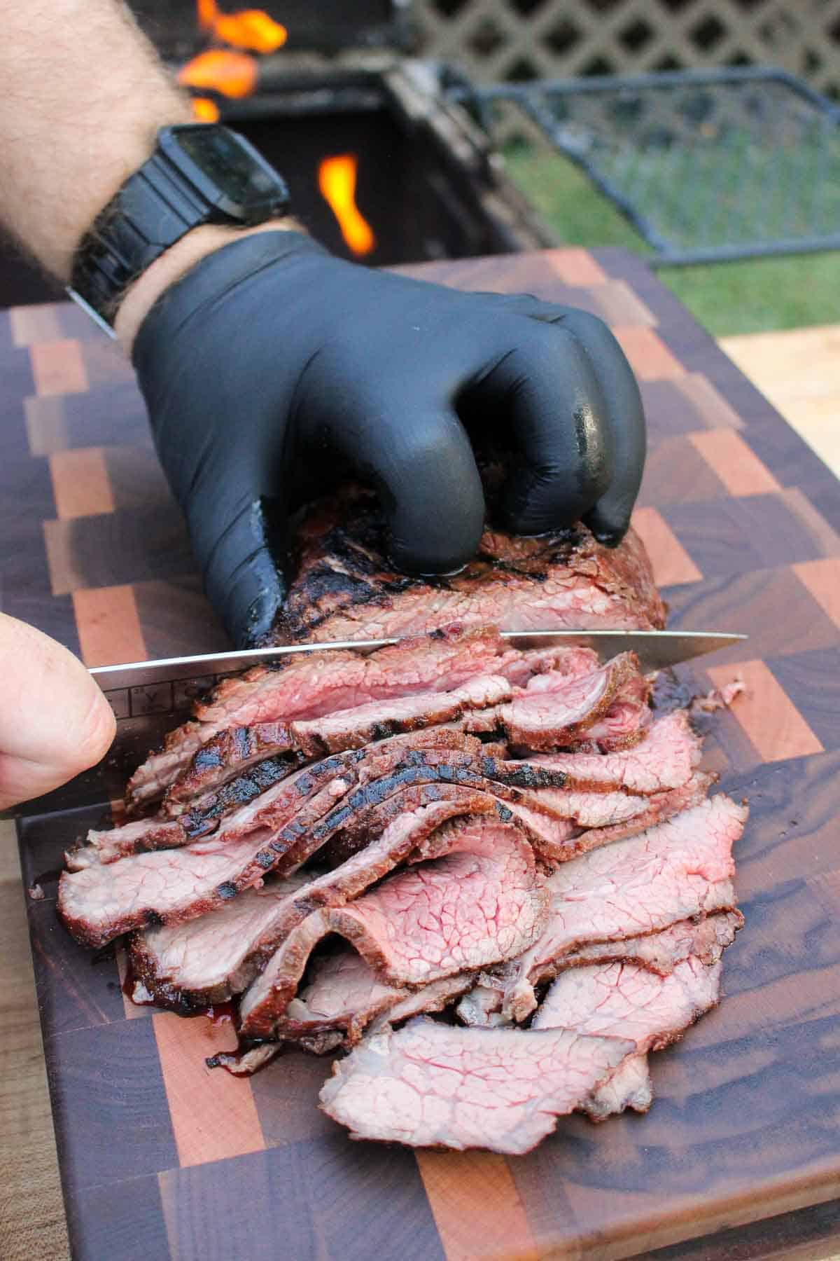 cooked steak being sliced on a cutting board