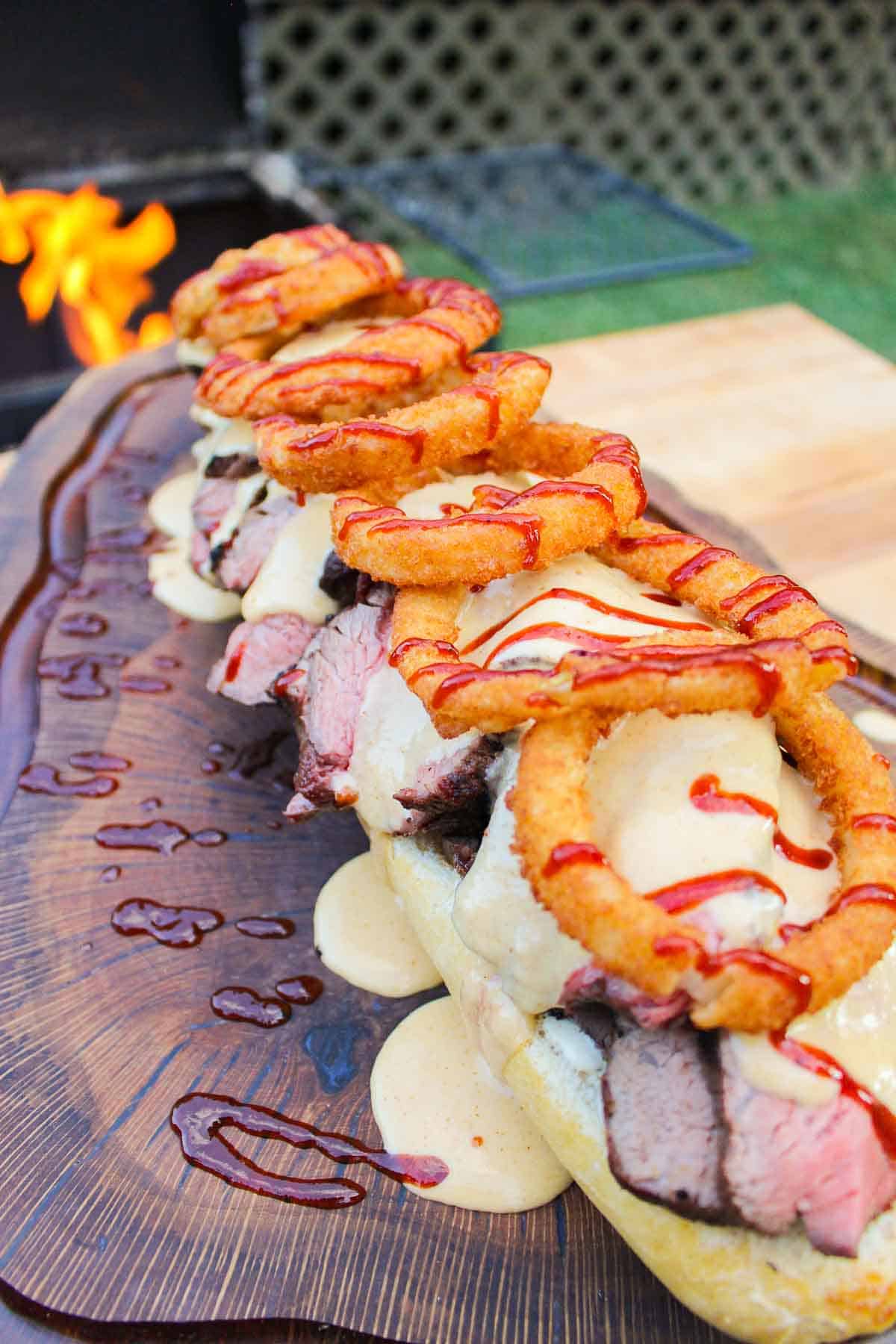 bbq steak sandwiches being assembled on a cutting board